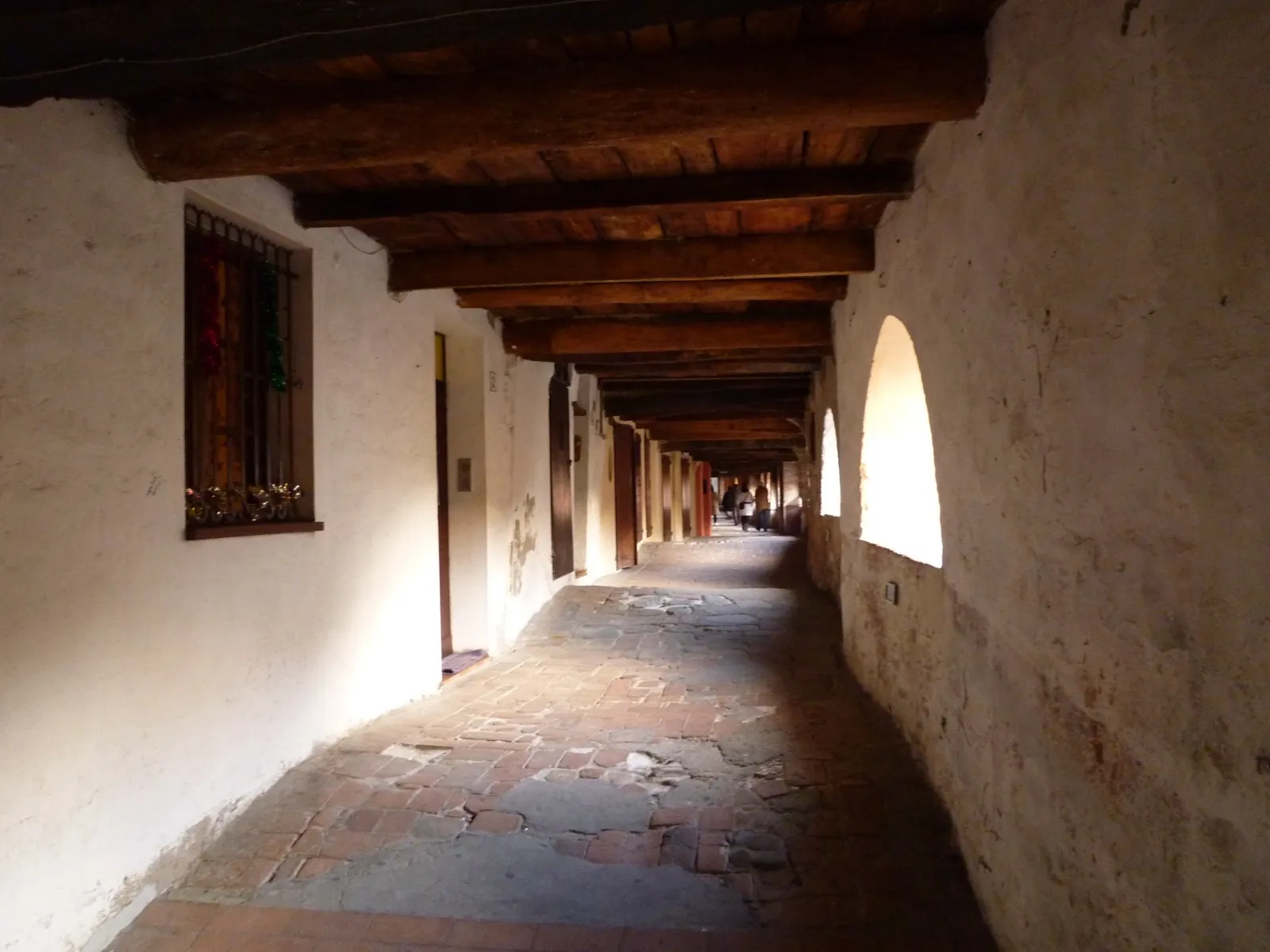 The covered, elevated street of Via degli Asini in Brisighella, between the coloured houses