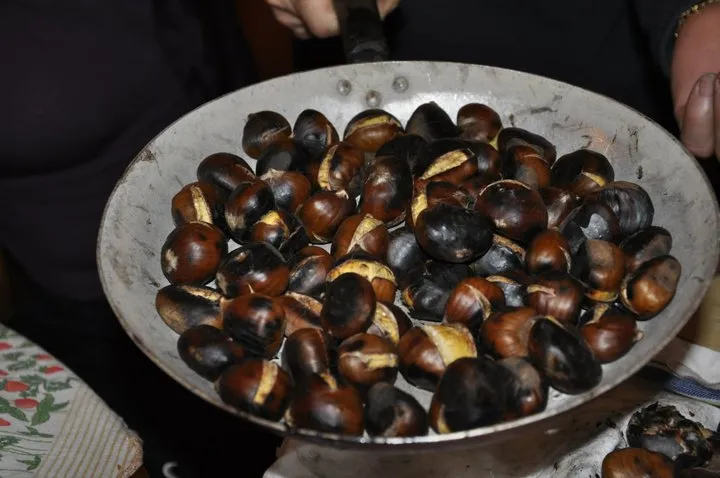 Roasted chestnuts in a holed pan over the fire