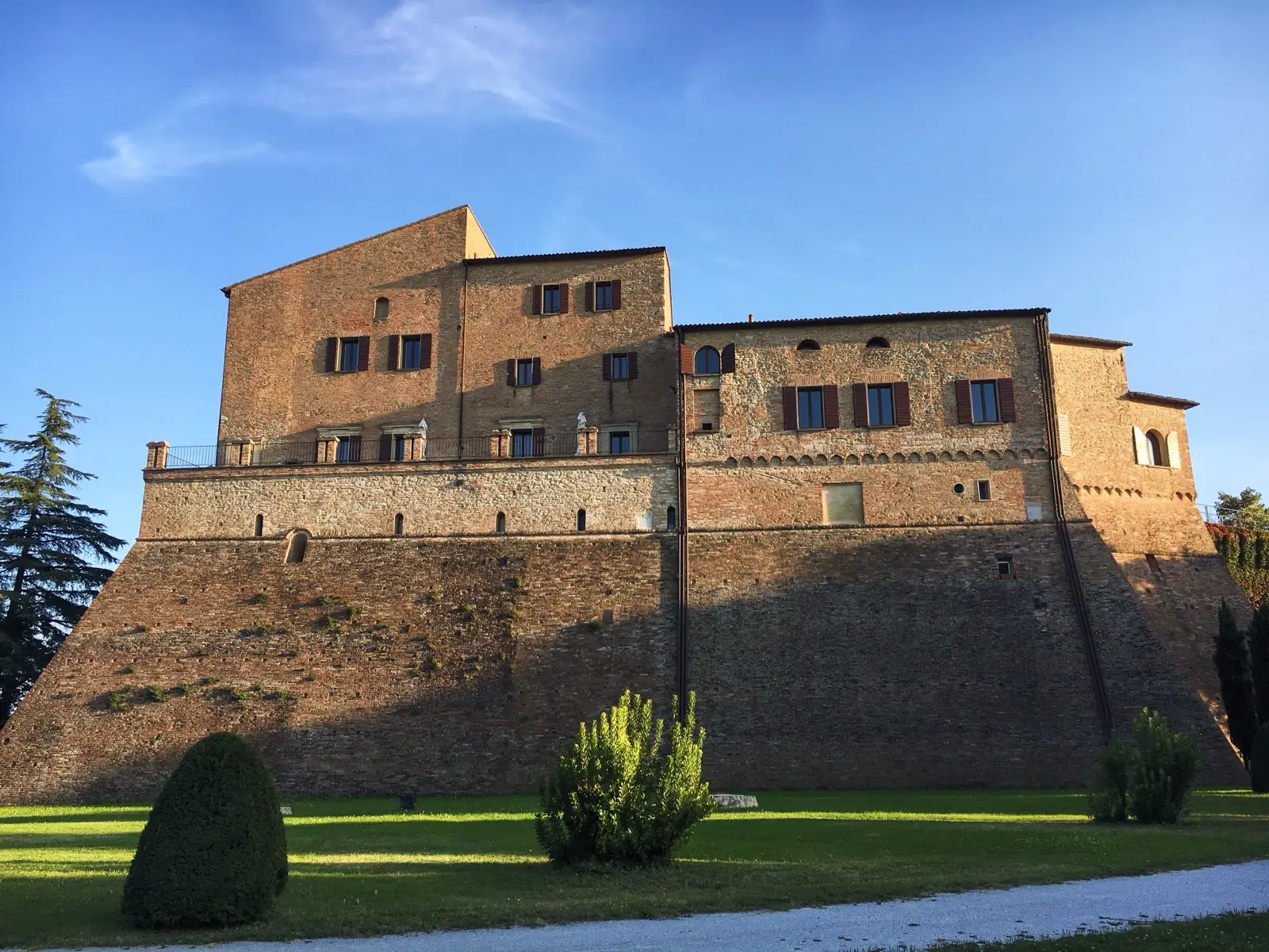 The stone walls of the fortress of Bertinoro among the trees